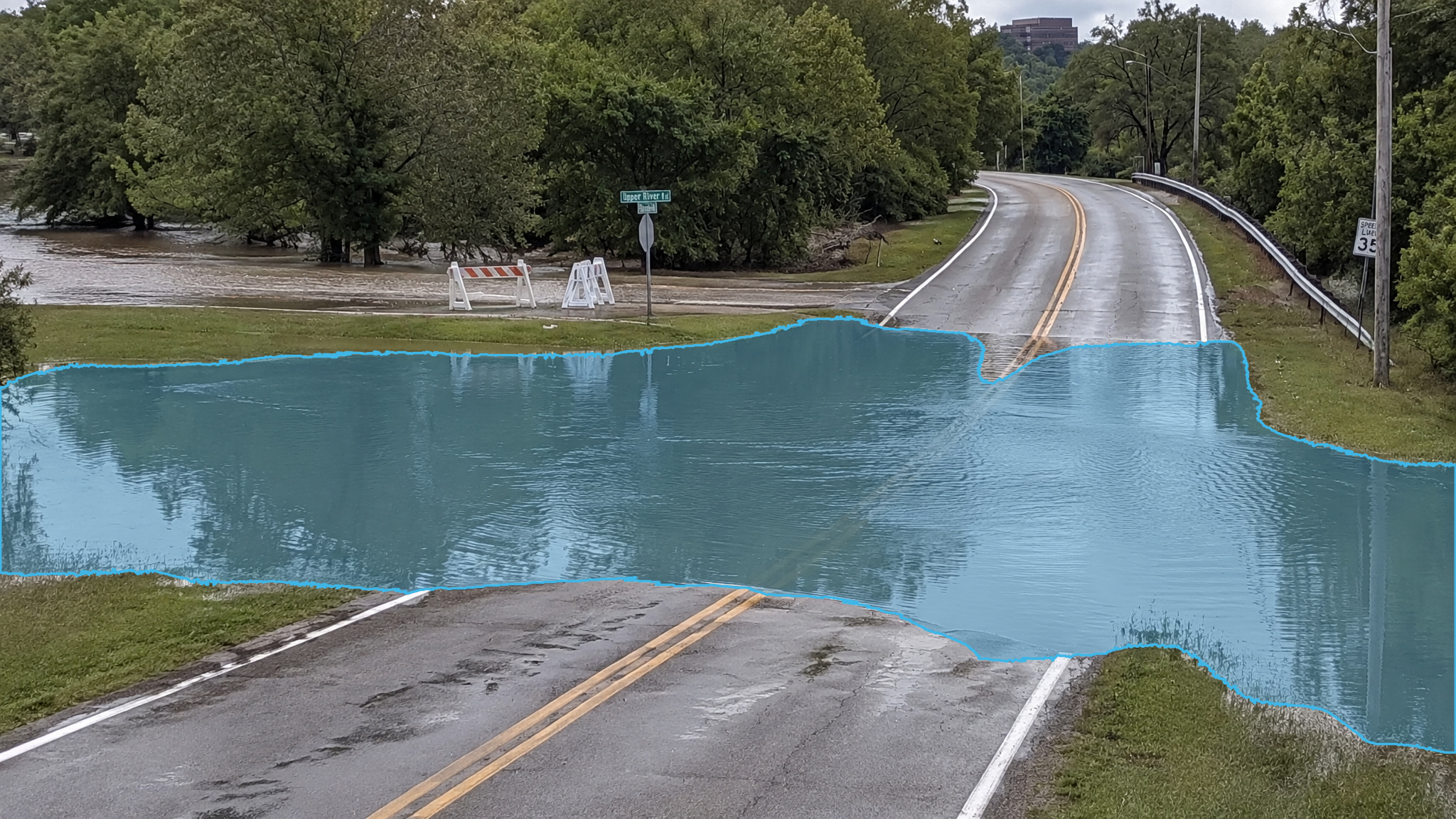 Flooded intersection in daylight. Blue detection overlay marks the standing water.