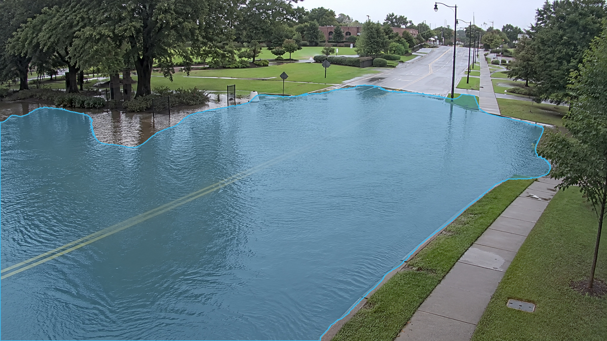 Flooded street in daylight. Blue detection overlay marks the standing water.